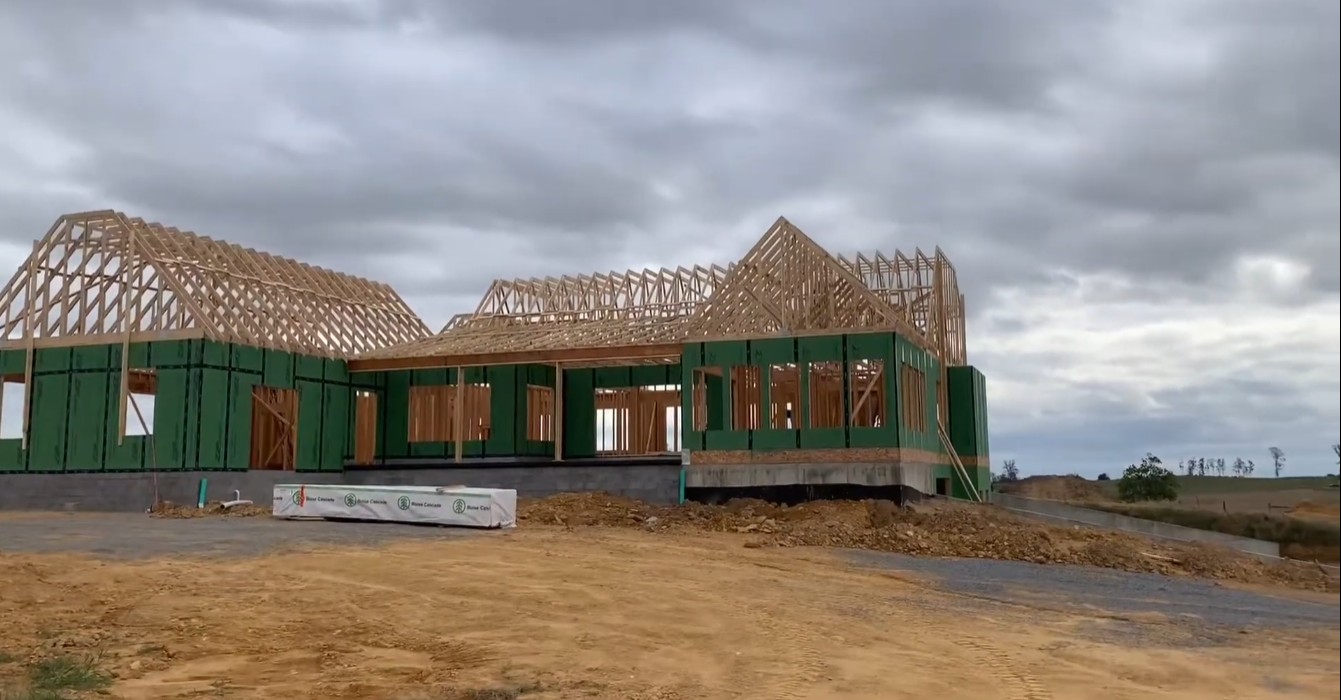 A home framed with TrussGuy roof trusses over green ZIP System wall sheathing on a Carolina jobsite